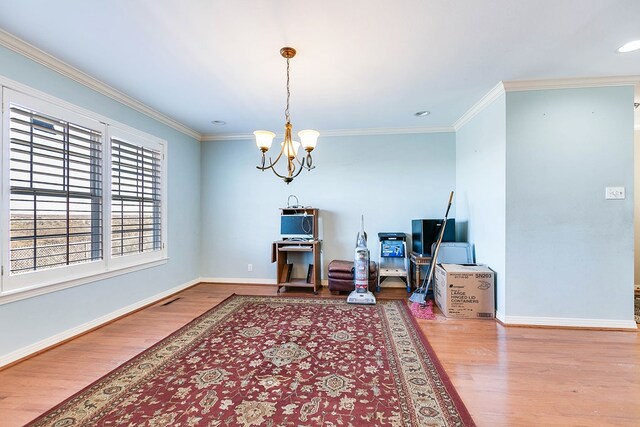 interior space featuring ornamental molding, hardwood / wood-style floors, and a notable chandelier