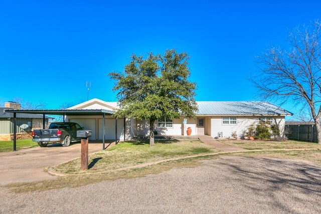 ranch-style house with a carport, a garage, and a front lawn