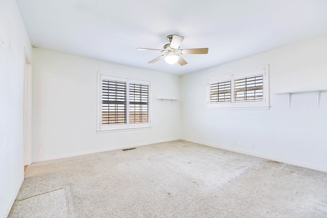 carpeted spare room with ceiling fan