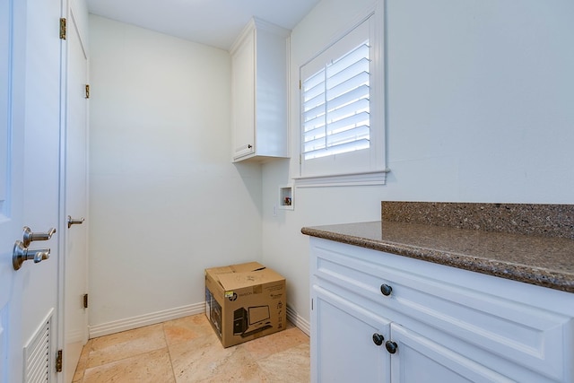 clothes washing area with washer hookup and cabinets