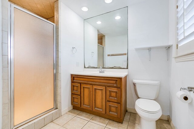 bathroom with toilet, vanity, tile patterned floors, and walk in shower