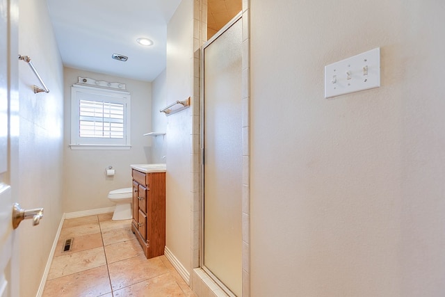 bathroom with vanity, a shower with shower door, tile patterned floors, and toilet