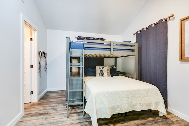 bedroom with lofted ceiling and wood-type flooring