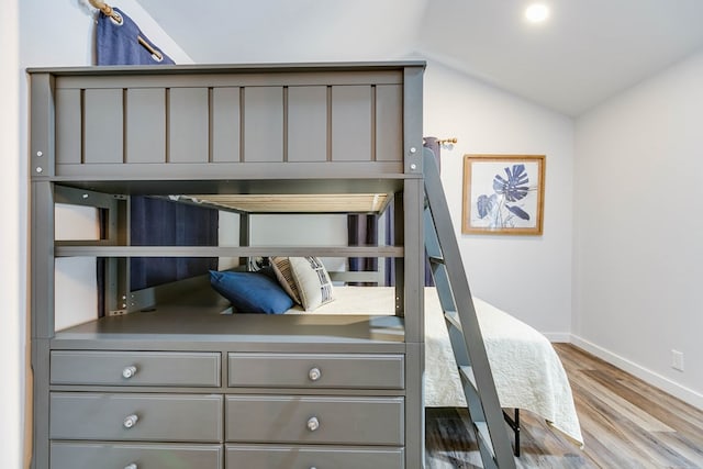 bedroom with vaulted ceiling and wood-type flooring