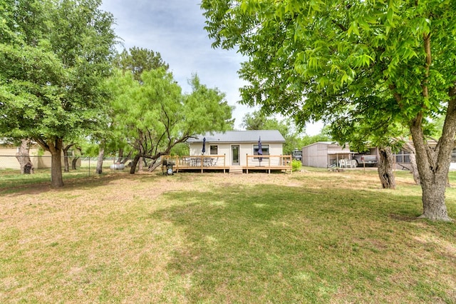 view of yard with a wooden deck and a storage unit