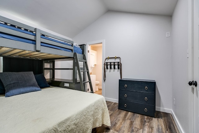 bedroom with dark hardwood / wood-style floors, lofted ceiling, and connected bathroom