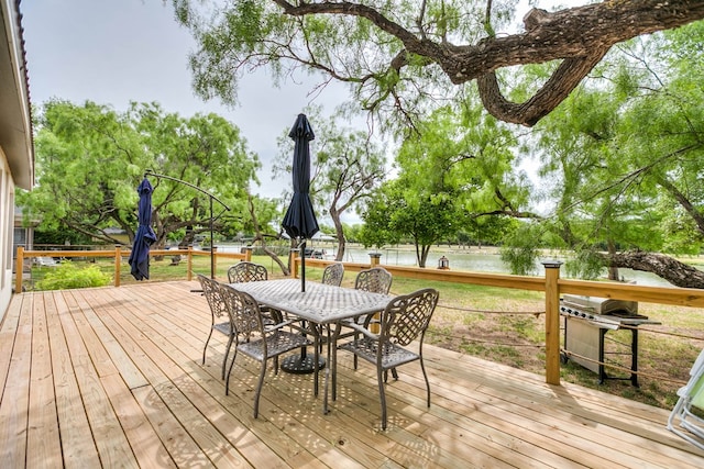 wooden terrace featuring a water view and a grill