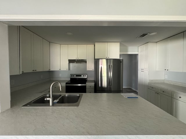 kitchen featuring white cabinetry, electric range oven, sink, and stainless steel refrigerator