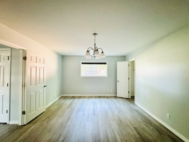 unfurnished dining area with an inviting chandelier and hardwood / wood-style floors