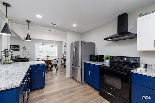 kitchen with blue cabinetry, decorative light fixtures, wall chimney range hood, light hardwood / wood-style floors, and black appliances