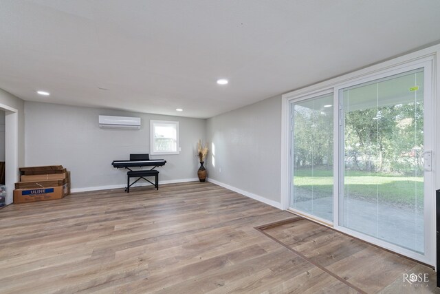 interior space with light hardwood / wood-style floors and a wall unit AC