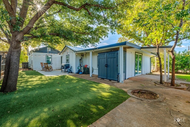 back of property with a yard and a patio area