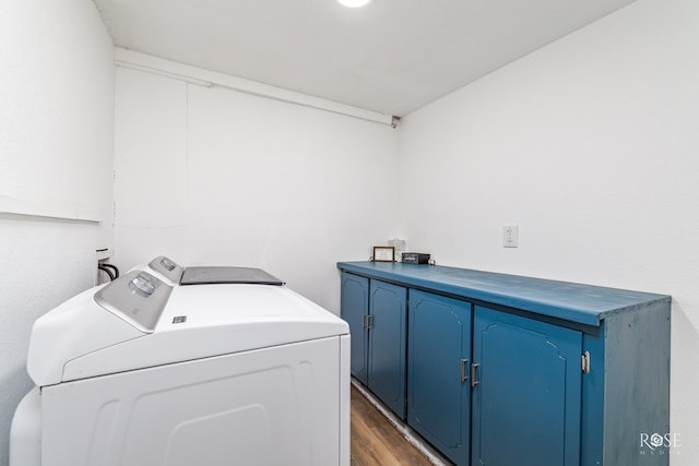 laundry room with dark hardwood / wood-style flooring, washer and clothes dryer, and cabinets