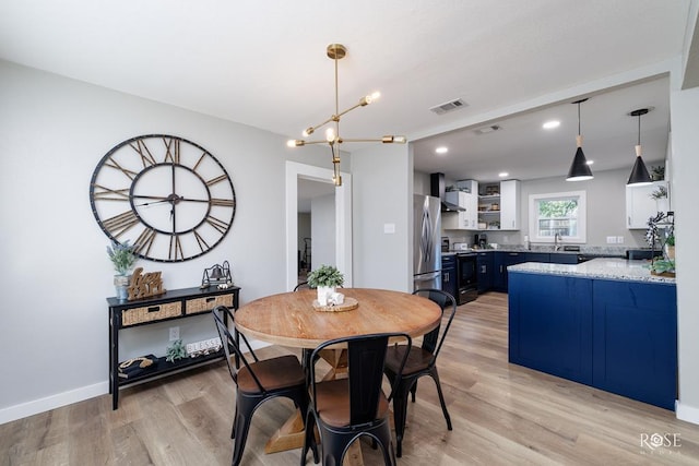 dining area featuring sink and light wood-type flooring