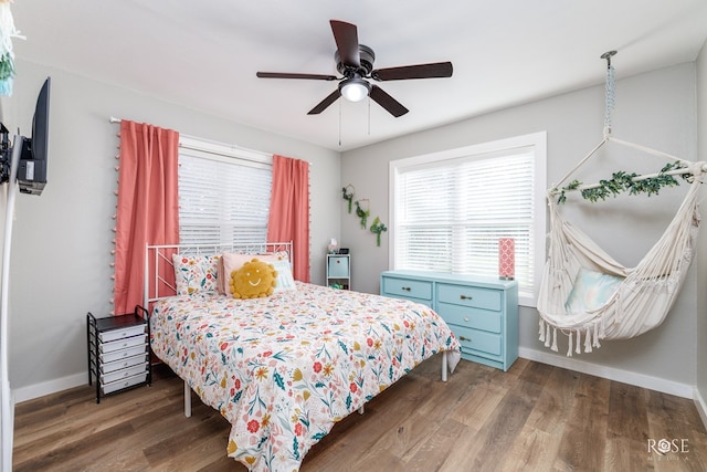 bedroom with dark hardwood / wood-style flooring and ceiling fan