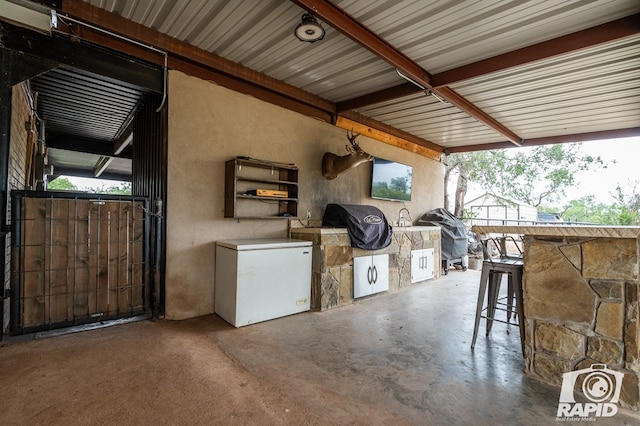 view of patio with area for grilling, grilling area, and exterior bar