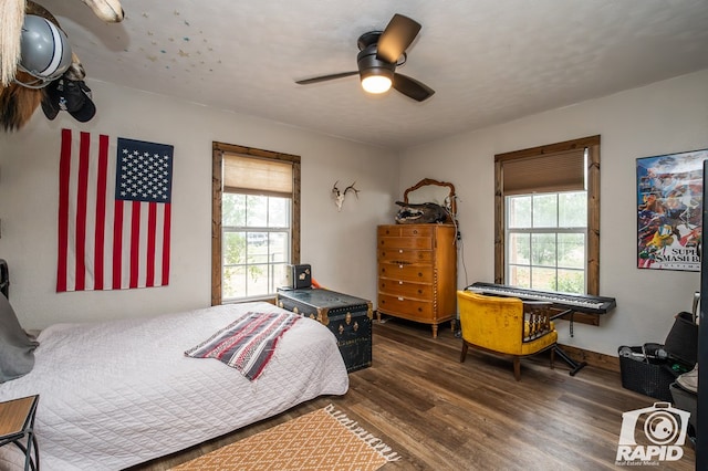 bedroom with multiple windows, a textured ceiling, dark hardwood / wood-style floors, and ceiling fan