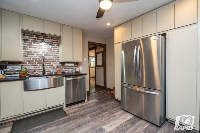 kitchen with sink, ceiling fan, stainless steel appliances, dark wood-type flooring, and a textured ceiling