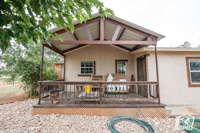 rear view of property featuring a wooden deck