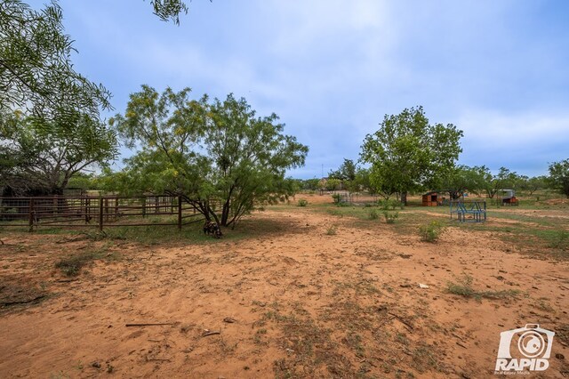 view of yard featuring a rural view and a storage shed