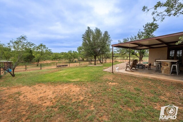 view of yard with a patio, an outdoor bar, and a rural view