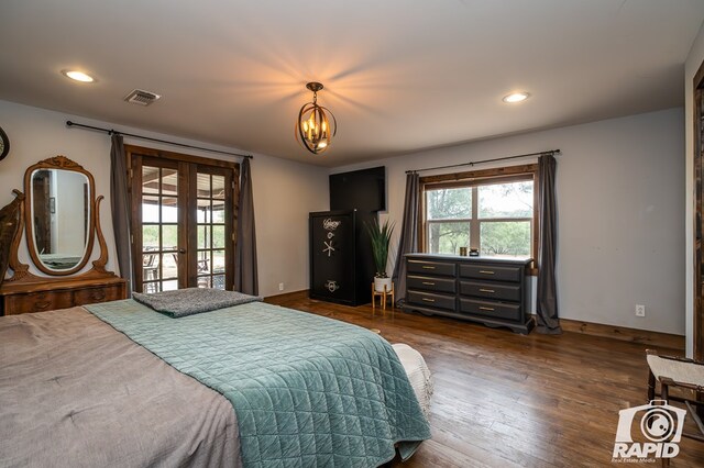 bedroom with an inviting chandelier, dark hardwood / wood-style floors, and french doors