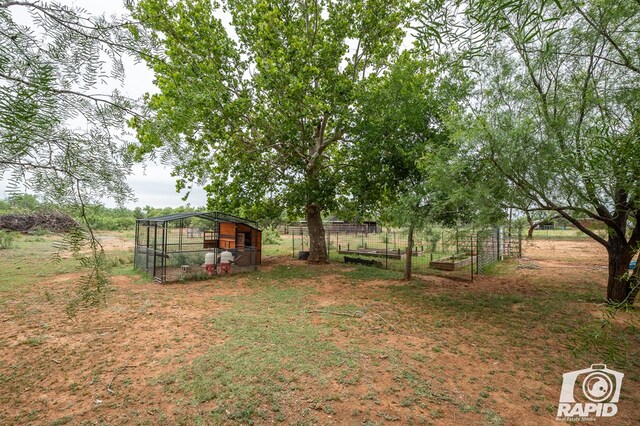 view of yard featuring an outdoor structure and a rural view