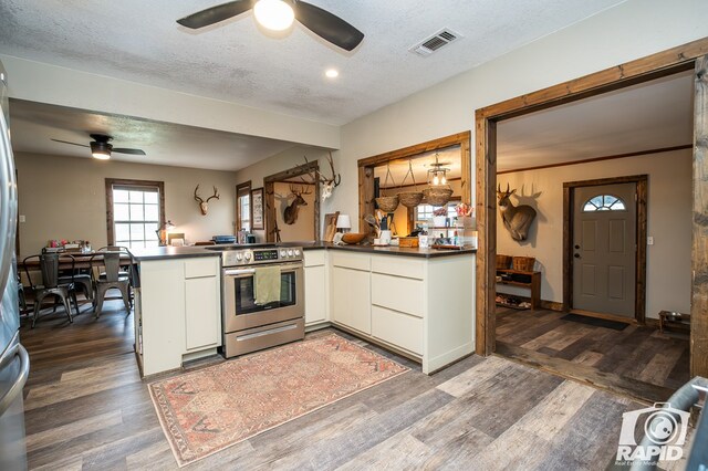 kitchen featuring electric stove, kitchen peninsula, dark wood-type flooring, and a textured ceiling