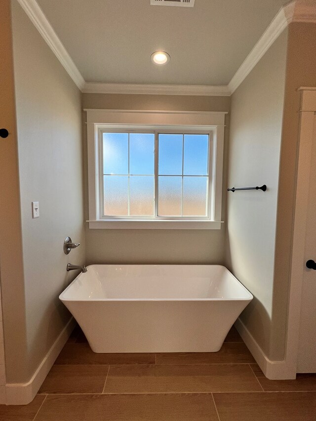 bathroom with a bathtub, wood-type flooring, and ornamental molding