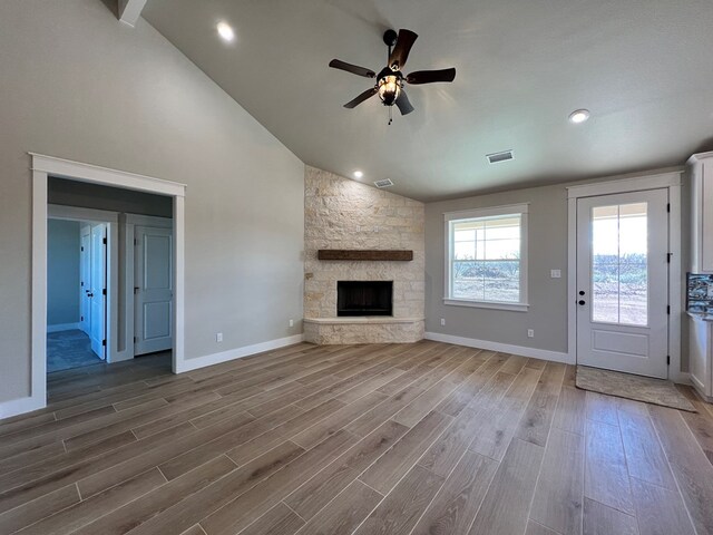 unfurnished living room featuring hardwood / wood-style flooring, ceiling fan, a fireplace, and high vaulted ceiling