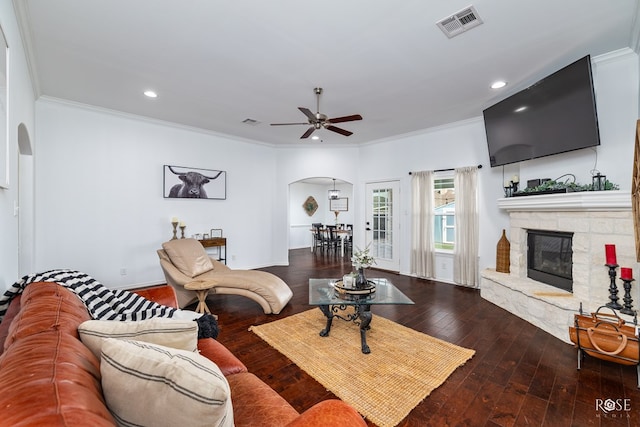 living room featuring hardwood / wood-style flooring, a fireplace, crown molding, and ceiling fan