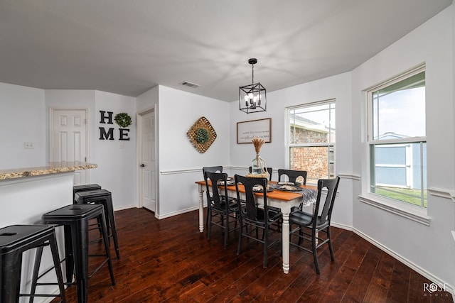 dining space with a notable chandelier and dark hardwood / wood-style floors