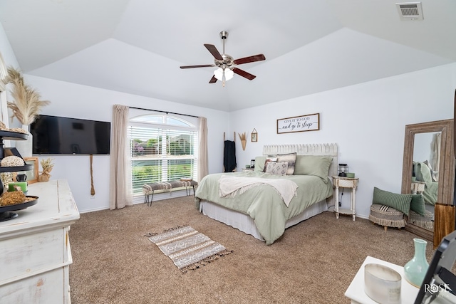 carpeted bedroom featuring a tray ceiling, vaulted ceiling, and ceiling fan