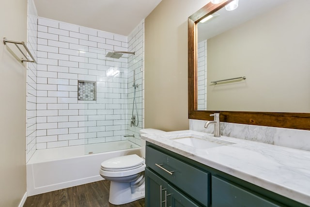 full bathroom with vanity, hardwood / wood-style flooring, tiled shower / bath combo, and toilet