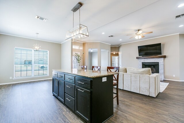 kitchen featuring plenty of natural light, a kitchen breakfast bar, decorative light fixtures, and a kitchen island