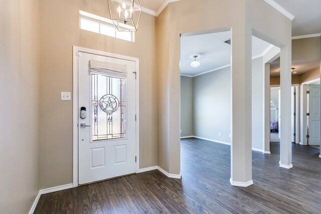 foyer featuring ornamental molding, dark wood-type flooring, and a notable chandelier