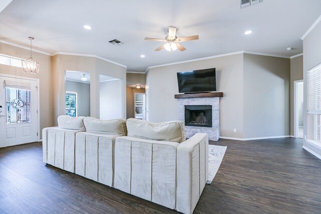 living room with crown molding, a fireplace, and dark hardwood / wood-style flooring