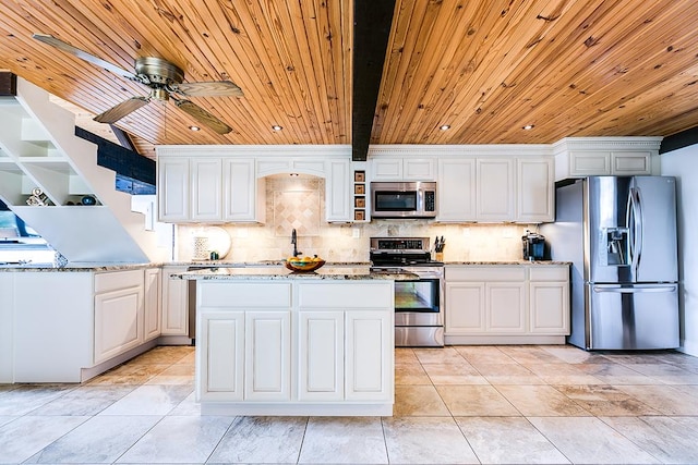 kitchen featuring light stone counters, white cabinetry, appliances with stainless steel finishes, and backsplash