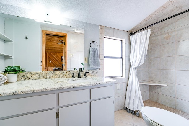 bathroom featuring toilet, a textured ceiling, vanity, a shower with shower curtain, and tile patterned flooring