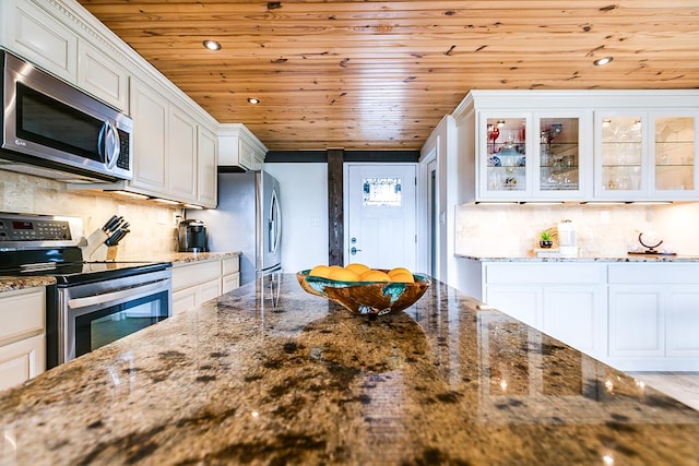 kitchen with white cabinetry, dark stone counters, and appliances with stainless steel finishes