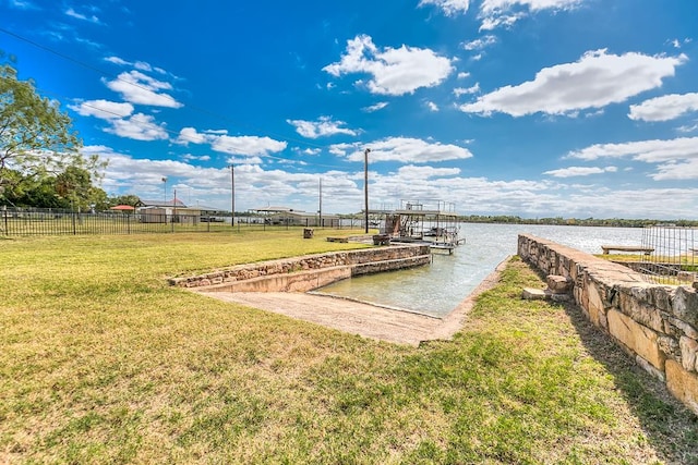 dock area with a lawn and a water view