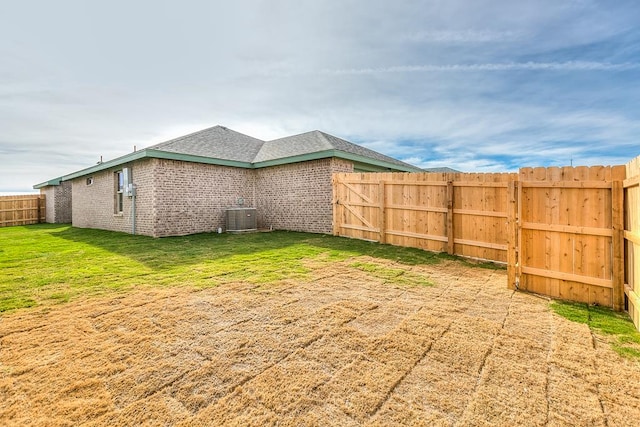 view of yard with central AC unit and a fenced backyard