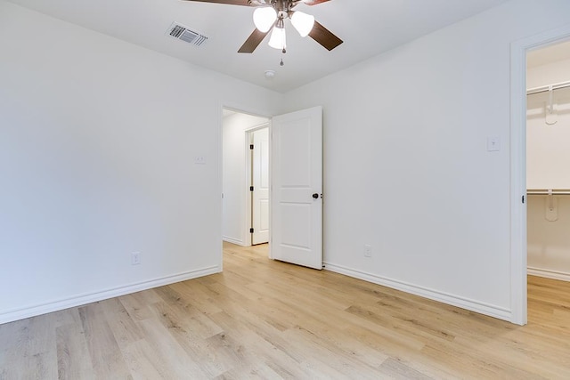 unfurnished room featuring light wood-type flooring, visible vents, baseboards, and ceiling fan