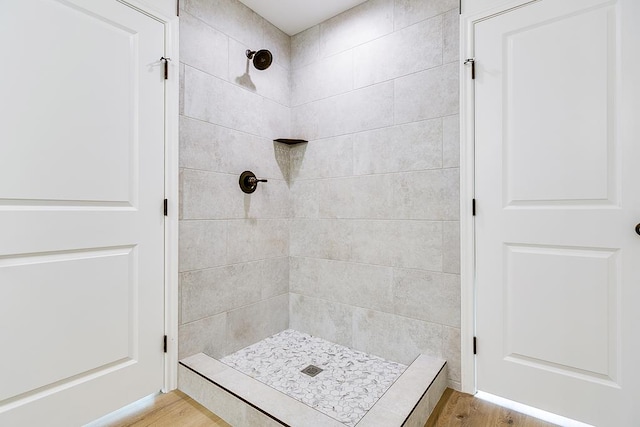 full bathroom featuring wood finished floors and a stall shower