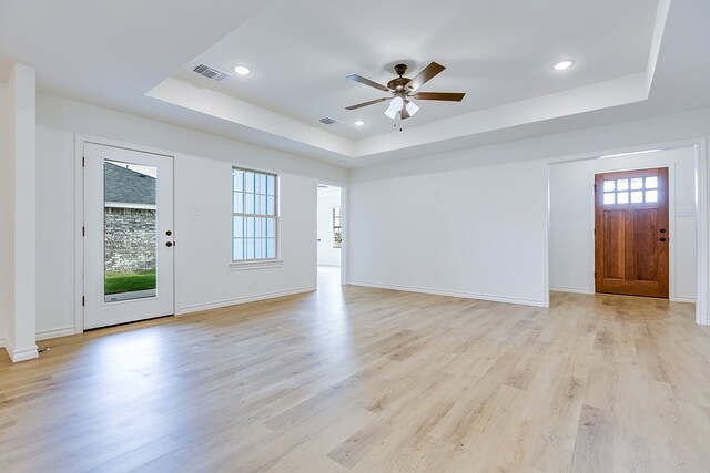 entrance foyer with visible vents, light wood-style flooring, and a raised ceiling