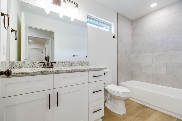 bathroom featuring shower / bathtub combination, toilet, vanity, and wood finished floors