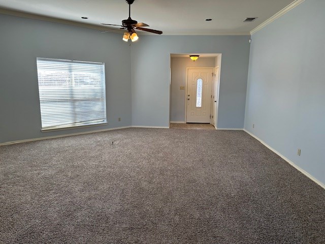 interior space with crown molding, ceiling fan, and carpet flooring