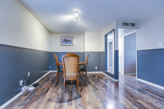 dining room featuring dark hardwood / wood-style floors and a textured ceiling