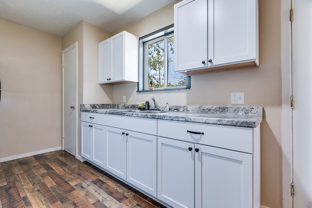 kitchen featuring sink, a textured ceiling, white cabinets, and dark hardwood / wood-style flooring