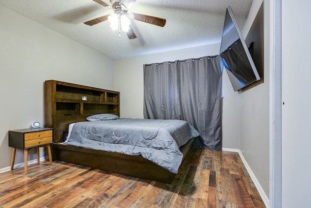 bedroom featuring ceiling fan, dark wood-type flooring, and a textured ceiling